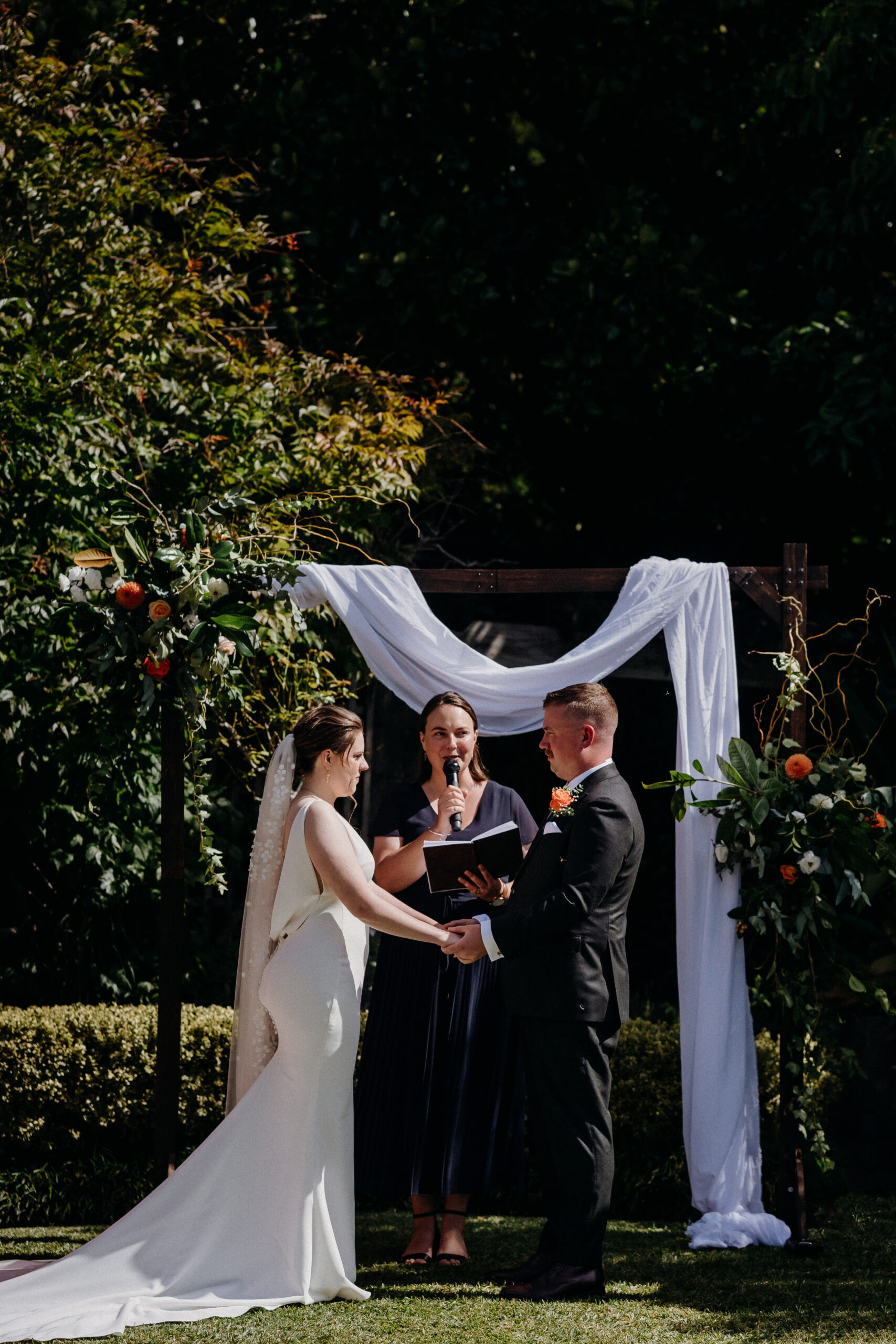 Long head table with a greenery runner and a fairy-light backdrop